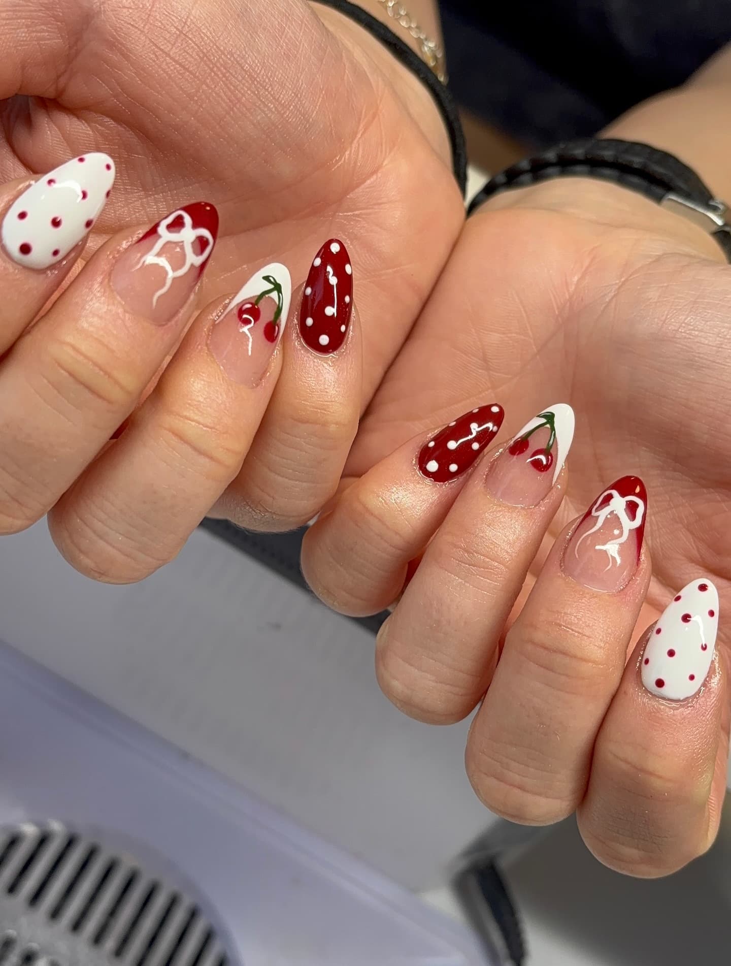 Red and white nail art with bow and cherry details
