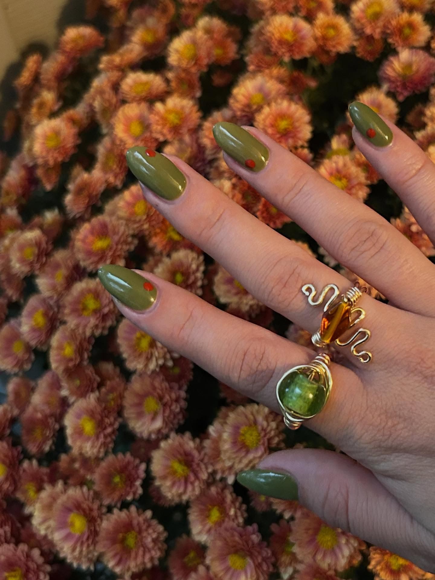 Olive green nail set with fall florals in the background